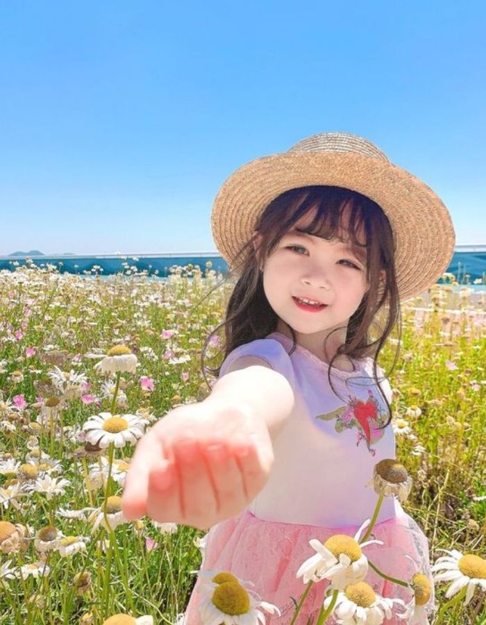 Bé gái tự tin tạo dáng chụp ảnh giữa vườn hoa