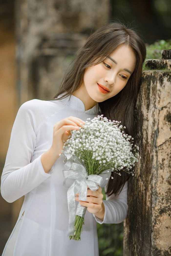 Hình ảnh nữ sinh tạo dáng chụp ảnh kỷ yếu cùng bó hoa