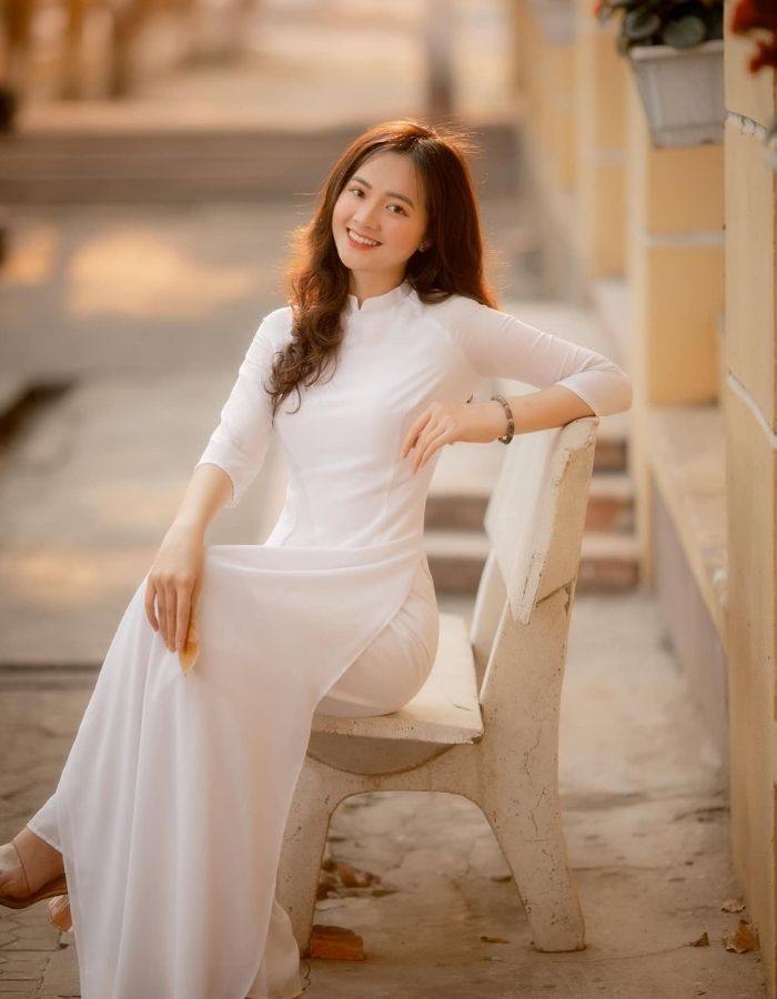 Tạo dáng chụp ảnh khi ngồi trên ghế đá nhà trường
